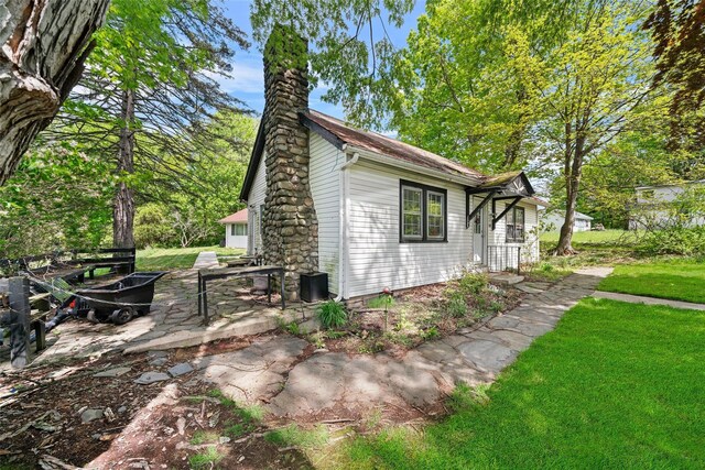 180-184 Pine Tree Rd, Monroe, NY 10950 - view of side of home featuring a chimney, a lawn, and a patio