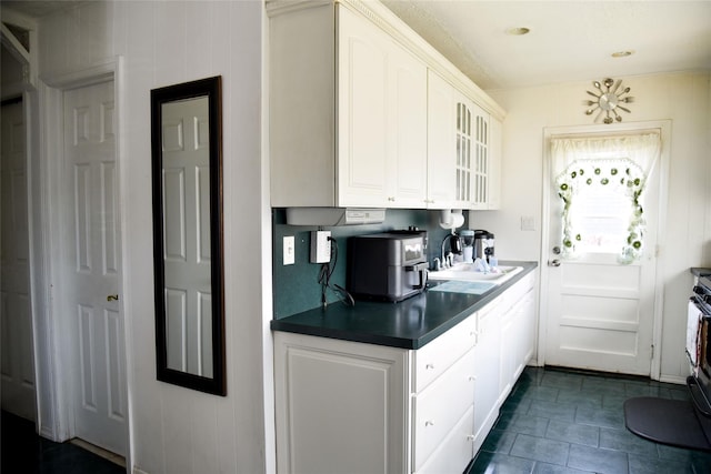 125 Timberline Dr, Brentwood, NY 11717 - kitchen with a sink, glass insert cabinets, dark countertops, white cabinetry, and dark tile patterned flooring