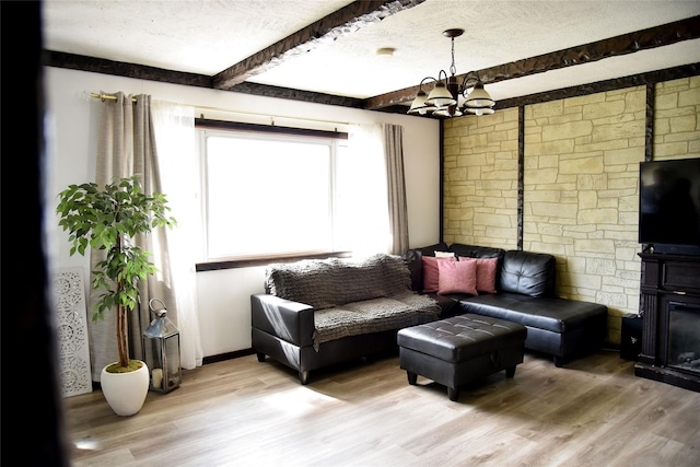 125 Timberline Dr, Brentwood, NY 11717 - living room with a chandelier, light wood-type flooring, beamed ceiling, and a textured ceiling