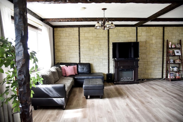 125 Timberline Dr, Brentwood, NY 11717 - living area with wood finished floors, a chandelier, beam ceiling, and a glass covered fireplace