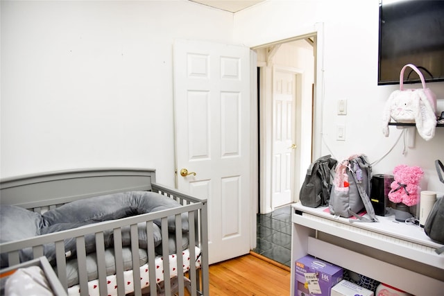 125 Timberline Dr, Brentwood, NY 11717 - bedroom featuring light wood-style floors and a nursery area