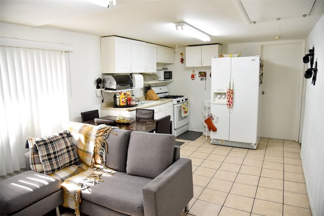 125 Timberline Dr, Brentwood, NY 11717 - kitchen featuring white appliances, light countertops, white cabinets, and light tile patterned floors