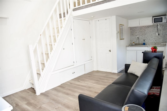 125 Timberline Dr, Brentwood, NY 11717 - living room featuring stairs, light wood-style floors, and baseboards