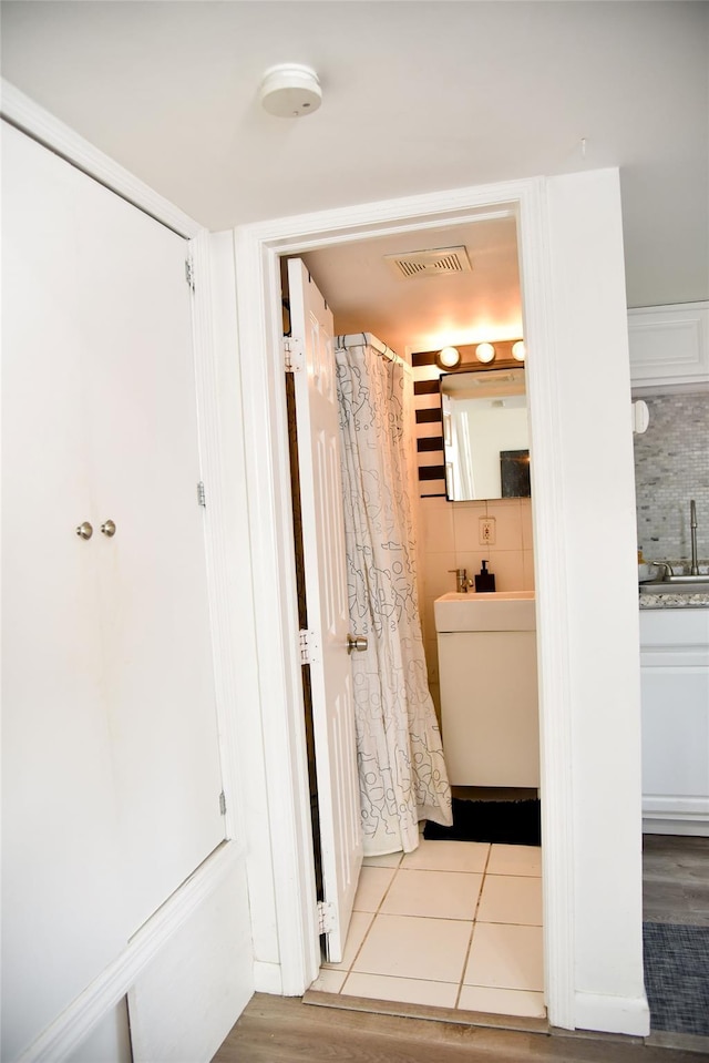 125 Timberline Dr, Brentwood, NY 11717 - bathroom featuring vanity, tile patterned flooring, and decorative backsplash