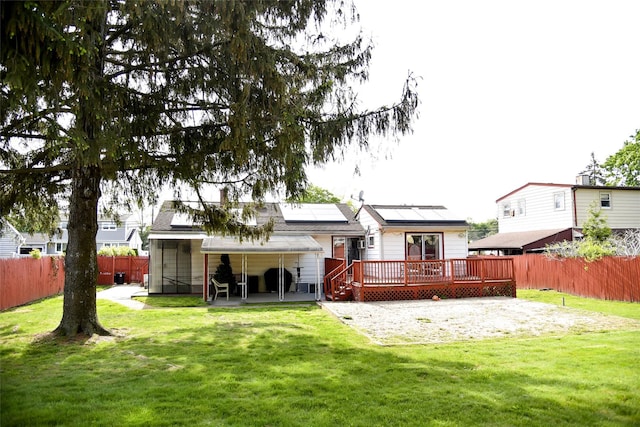 125 Timberline Dr, Brentwood, NY 11717 - back of property with a deck, roof mounted solar panels, and a patio area