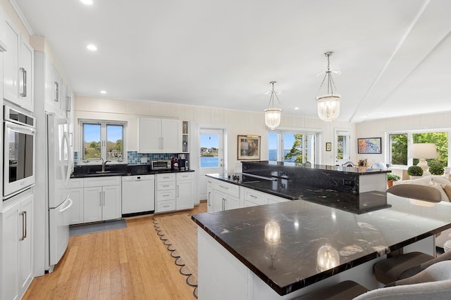 47 Rampasture Rd Apt M, Hampton Bays, NY 11946 - kitchen featuring white appliances, healthy amount of natural light, open shelves, a kitchen breakfast bar, and recessed lighting