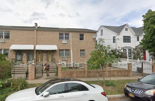 214-27 38th Ave, Bayside, NY 11361 - view of front of house with a fenced front yard, brick siding, and a gate