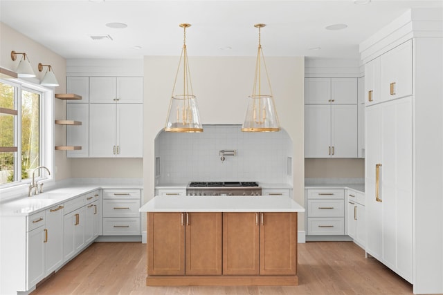 kitchen with open shelves, light wood-type flooring, a center island, and light countertops