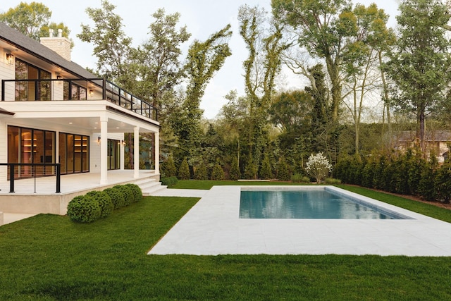 swimming pool featuring a patio area and a yard