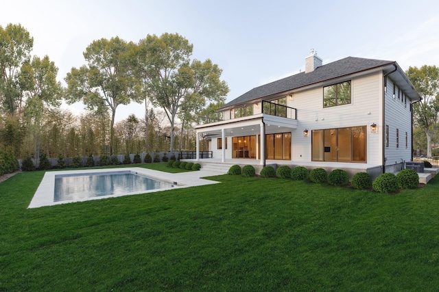 back of property with a balcony, a chimney, and cooling unit