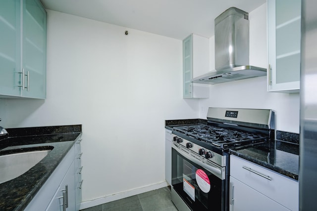 88-20 Parsons Blvd Unit 6D, Jamaica, NY 11432 - kitchen with stainless steel gas stove, exhaust hood, a sink, white cabinetry, and dark stone counters