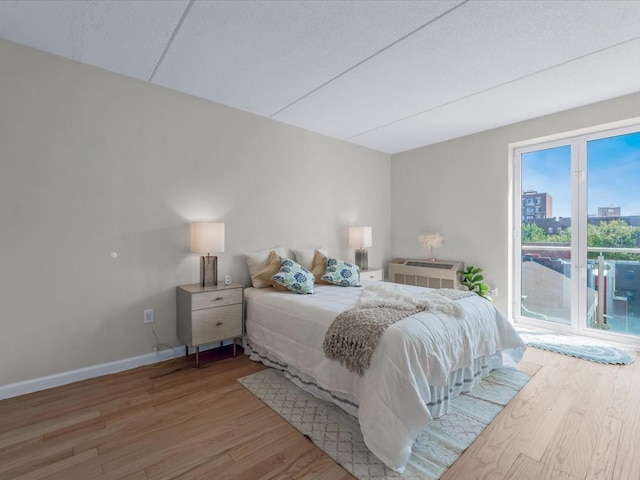 88-20 Parsons Blvd Unit 6D, Jamaica, NY 11432 - bedroom featuring access to outside, wood finished floors, baseboards, a wall unit AC, and a view of city