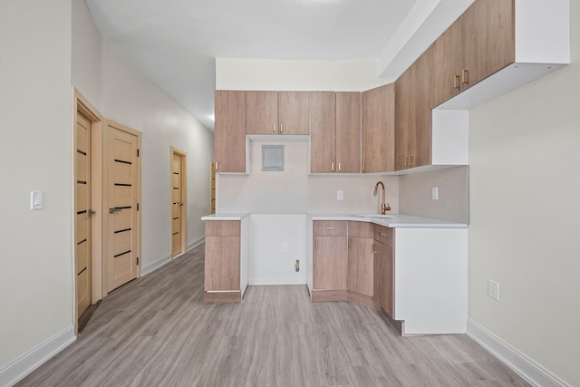 530 Sutter Ave, Brooklyn, NY 11207 - kitchen featuring a sink, light wood-style flooring, light countertops, and baseboards