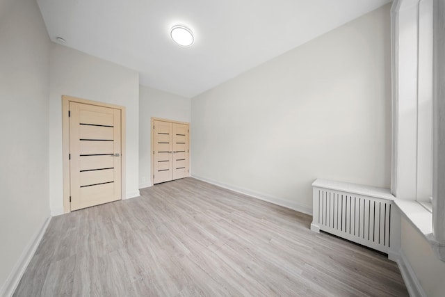 530 Sutter Ave, Brooklyn, NY 11207 - unfurnished bedroom with radiator heating unit, wood finished floors, and baseboards