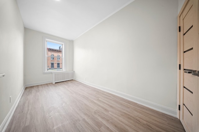 530 Sutter Ave, Brooklyn, NY 11207 - spare room featuring radiator, light wood-style flooring, baseboards, and lofted ceiling