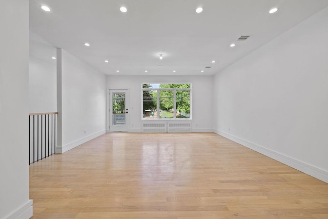 spare room with light wood-type flooring, recessed lighting, and baseboards