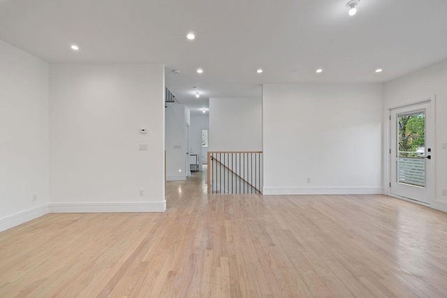 spare room featuring light wood-style floors, recessed lighting, and baseboards