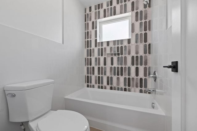 bathroom featuring toilet, shower / bathtub combination, and tile walls