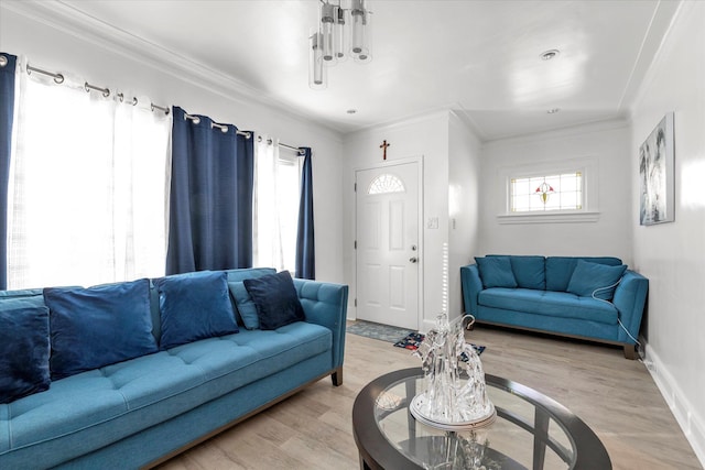living room featuring light wood-style floors, baseboards, and ornamental molding