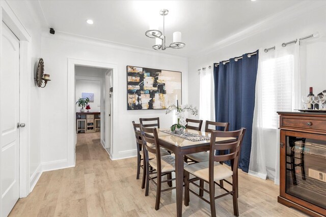 dining space featuring a chandelier, light wood-style floors, and baseboards