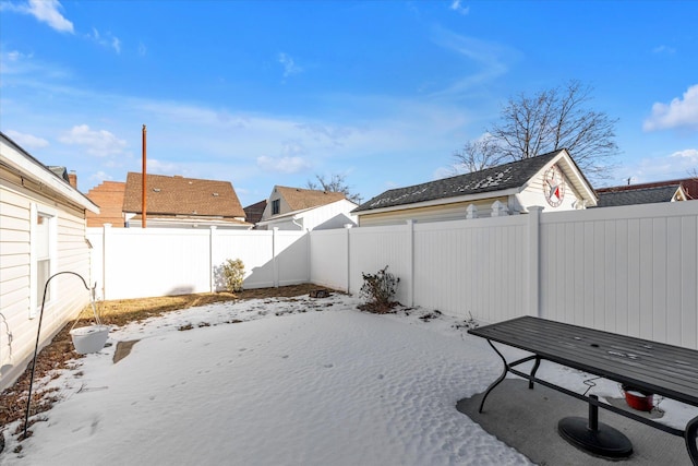 yard layered in snow with a fenced backyard