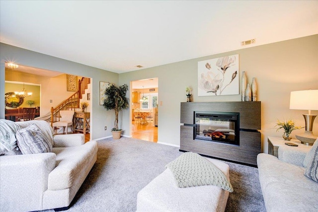 7 Cambridge Cir, Monroe, NY 10950 - carpeted living room featuring stairway, a chandelier, a multi sided fireplace, and baseboards