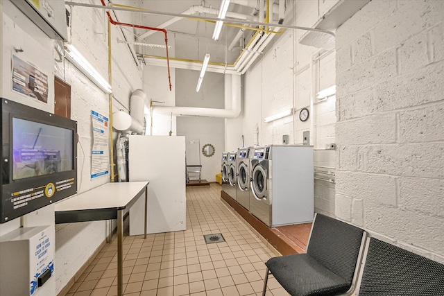 98-51 64th Ave Unit 2C, Rego Park, NY 11374 - community laundry room with washer and clothes dryer, concrete block wall, and light tile patterned floors