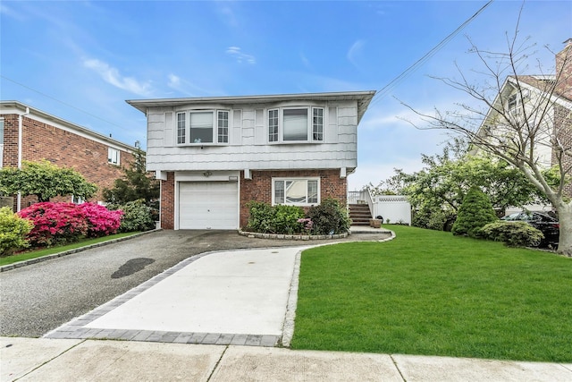 view of front of home with driveway, brick siding, a front lawn, and an attached garage