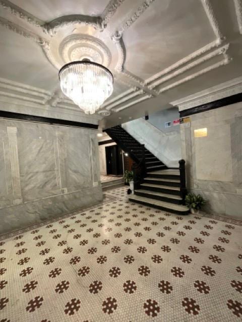 below grade area featuring stairs and a chandelier