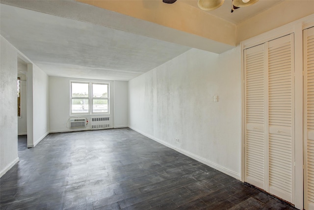 3901 Nostrand Ave Unit 3T, Brooklyn, NY 11235 - unfurnished living room featuring radiator heating unit, dark wood-style flooring, a wall unit AC, and baseboards