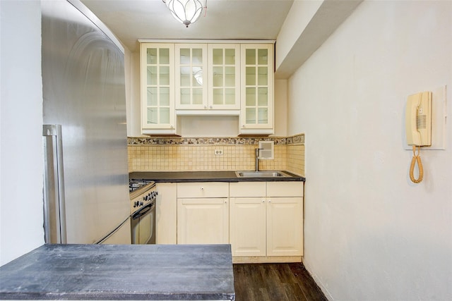 3901 Nostrand Ave Unit 3T, Brooklyn, NY 11235 - kitchen featuring dark countertops, a sink, range with gas stovetop, dark wood-style flooring, and tasteful backsplash