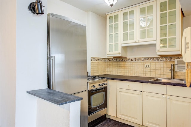 3901 Nostrand Ave Unit 3T, Brooklyn, NY 11235 - kitchen with appliances with stainless steel finishes, dark countertops, a sink, and glass insert cabinets