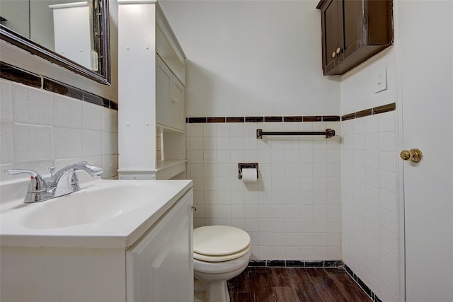 3901 Nostrand Ave Unit 3T, Brooklyn, NY 11235 - half bathroom with tile walls, toilet, wood finished floors, vanity, and wainscoting