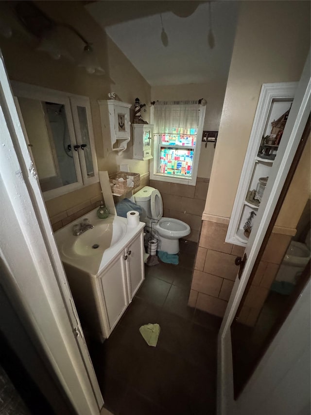 bathroom featuring toilet, vanity, tile patterned flooring, and lofted ceiling