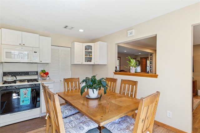 dining area with light wood-type flooring, baseboards, and recessed lighting