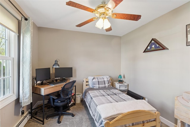 carpeted bedroom with a baseboard heating unit, a desk, a ceiling fan, and baseboards