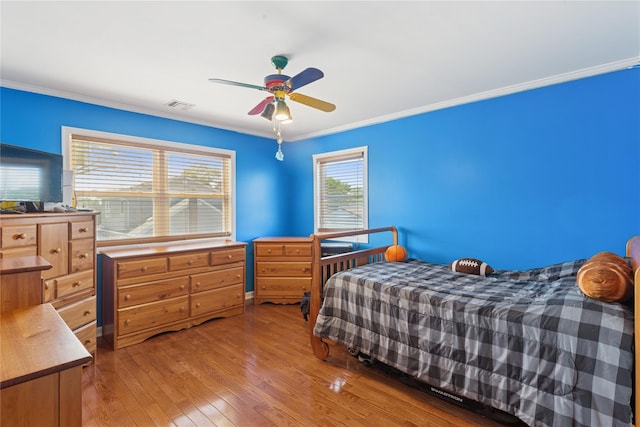 bedroom with ornamental molding, hardwood / wood-style floors, and ceiling fan