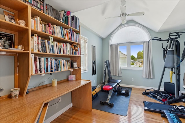 exercise area with plenty of natural light, wood finished floors, ceiling fan, vaulted ceiling, and baseboards