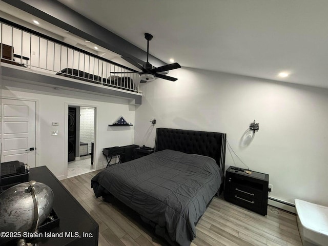 bedroom featuring a baseboard heating unit, light wood-type flooring, vaulted ceiling, recessed lighting, and a ceiling fan