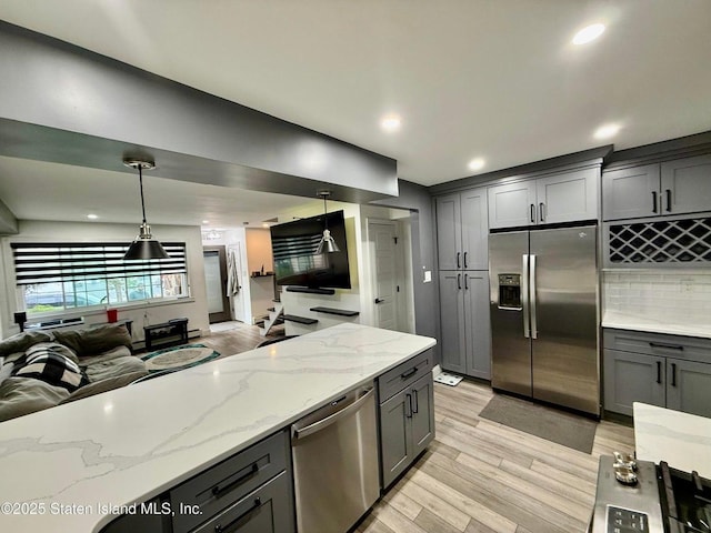 kitchen with stainless steel appliances, gray cabinets, light wood-type flooring, open floor plan, and recessed lighting