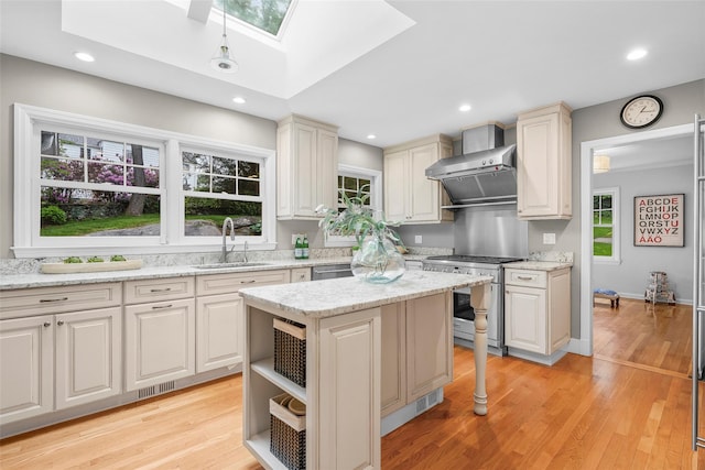 3 Briar Close Rd, Larchmont, NY 10538 - kitchen with high end range, a sink, wall chimney range hood, a skylight, and recessed lighting