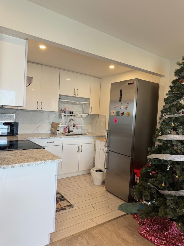 524 115th St Unit 524C, Flushing, NY 11356 - kitchen featuring black appliances, a sink, white cabinets, backsplash, and recessed lighting