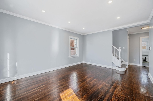 unfurnished room featuring plenty of natural light, stairway, wood finished floors, baseboards, and crown molding