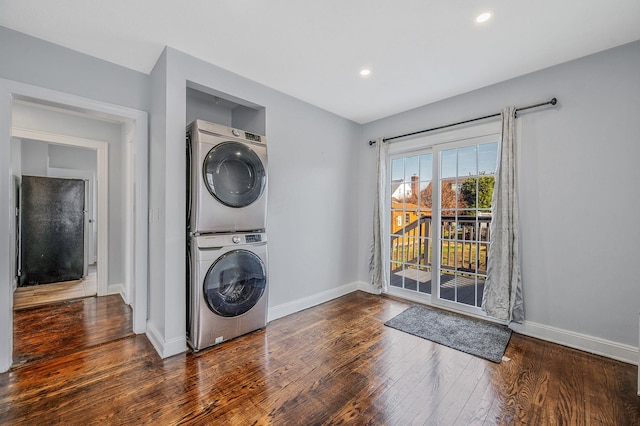 laundry room with stacked washing machine and dryer, baseboards, wood-type flooring, and recessed lighting