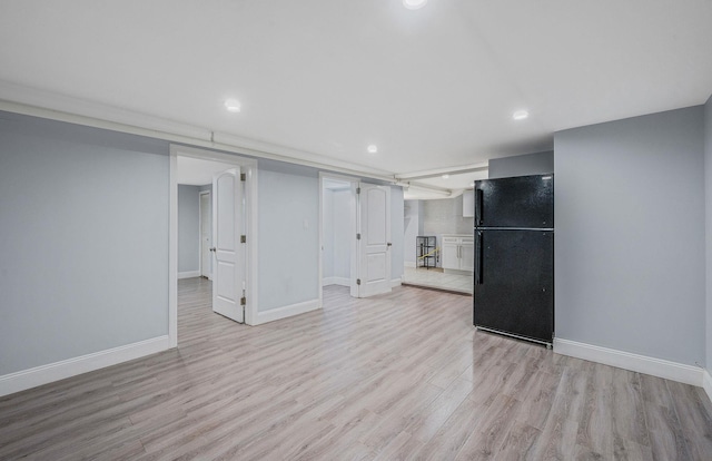 finished below grade area with freestanding refrigerator, light wood-style flooring, baseboards, and recessed lighting