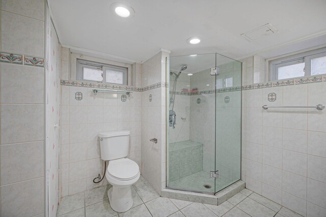 bathroom with tile walls, a stall shower, tile patterned flooring, toilet, and recessed lighting