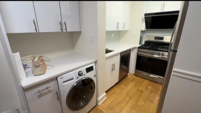 142-20 Franklin Ave Unit 2V, Flushing, NY 11355 - kitchen with washer / clothes dryer, stainless steel range with gas stovetop, light wood finished floors, white cabinetry, and light countertops
