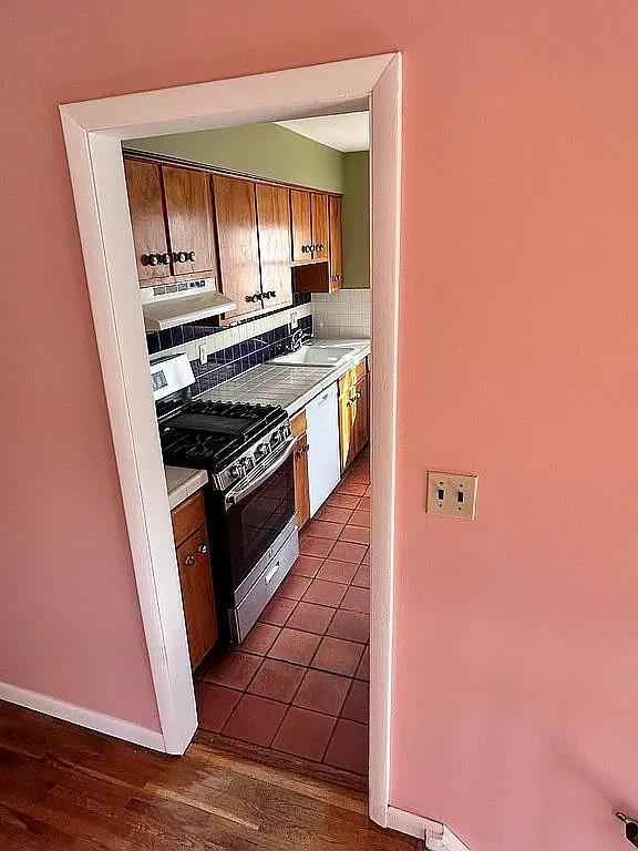 102 Maple St, Croton-On-Hudson, NY 10520 - kitchen with stainless steel range with gas cooktop, under cabinet range hood, dishwasher, light countertops, and backsplash