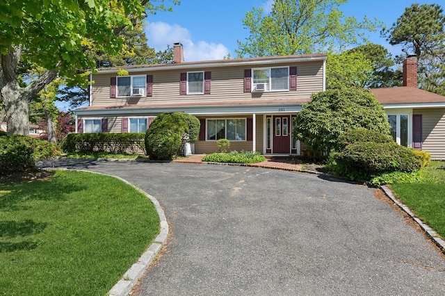 291 E Woodside Ave, East Patchogue, NY 11772 - traditional-style home featuring a chimney, driveway, and a front lawn