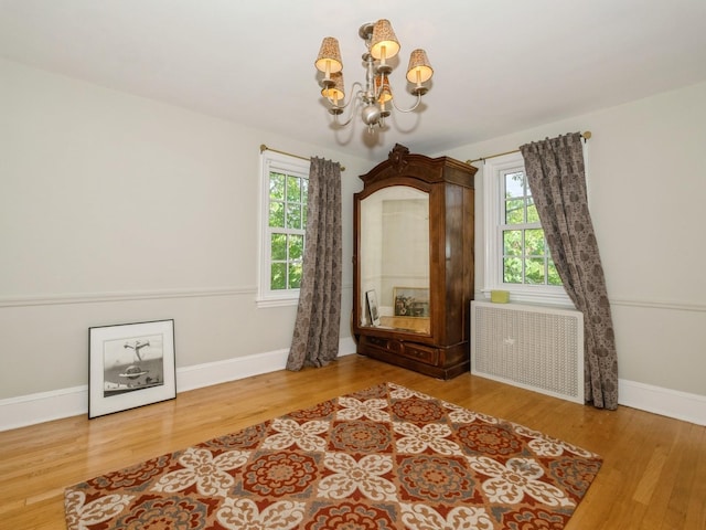 98 Jackson St, Fishkill, NY 12524 - unfurnished room featuring radiator, a chandelier, and wood finished floors